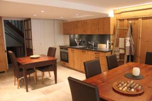 a kitchen with a wooden table and a dining room at L'ancienne Poste - Maison Napoléon in Bourg-Saint-Pierre