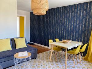a living room with a blue couch and a table at L'escale Granvillaise in Granville