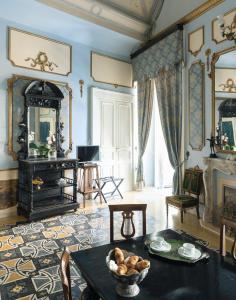 uma sala de estar com uma mesa e uma lareira em Carafa di Maddaloni By Enjoy Napoli em Nápoles