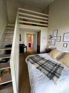 um quarto com uma cama ao lado de uma escada em Chambres d hotes, la maison de Kat em Lamothe-Capdeville