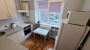 a small kitchen with a table and a refrigerator at Cietokšņa 55а-1 in Daugavpils