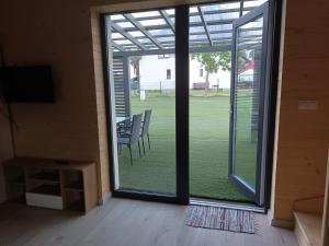 a room with a sliding glass door with chairs outside at Domek 6 os Oaza Kaszubska Studzienice in Studzienice