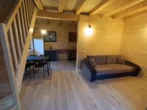 a living room with a couch and a table at Domek 6 os Oaza Kaszubska Studzienice in Studzienice