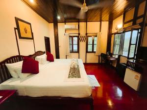 um quarto com 2 camas e almofadas vermelhas em Ban Lakkham River View em Luang Prabang