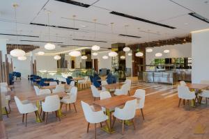 ein Restaurant mit Tischen und Stühlen und eine Cafeteria in der Unterkunft AKASIYA HOTEL in Doha