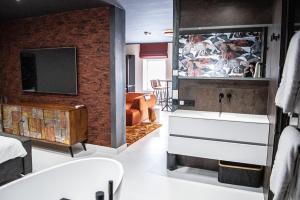 een badkamer met een wastafel en een tv in een kamer bij "DE BANK" - Hotel Apartments in Harlingen