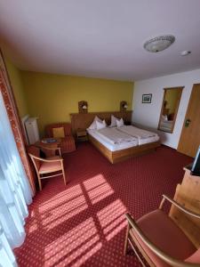 ein Hotelzimmer mit einem Bett und einem Stuhl in der Unterkunft Gästehaus Schwarz in Prien am Chiemsee