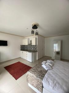 a white bedroom with a large bed and a red rug at Erbay Mansions Hotel in Trabzon