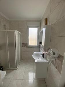 a white bathroom with a sink and a toilet at Erbay Mansions Hotel in Trabzon