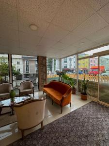 a large room with a couch and chairs and windows at Erbay Mansions Hotel in Trabzon