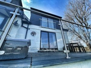 a house with a window on the side of it at Orchard Lodge -Coastal Retreat, new build, village views, private garden and terrace in Saint Brides Major