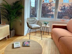 ein Wohnzimmer mit einem Sofa, einem Stuhl und einem Tisch in der Unterkunft Les Valcaprimontoises … en ville ! in Lüttich