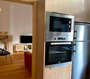 eine Küche mit einem Backofen aus Edelstahl und einem Kühlschrank in der Unterkunft Les Valcaprimontoises … en ville ! in Lüttich