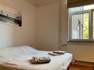 um quarto com uma cama com duas toalhas em Les Valcaprimontoises … en ville ! em Liège