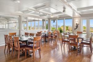 a dining room with tables and chairs and windows at Carousel Resort Hotel and Condominiums in Ocean City