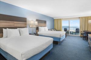 ein Hotelzimmer mit 2 Betten und einem Balkon in der Unterkunft Carousel Resort Hotel and Condominiums in Ocean City