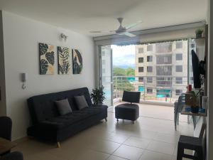 sala de estar con sofá y ventana grande en Apartamento vacacional en Girardot Cundinamarca - AQUALINA ORANGE piso 3 vista a la piscina, en Bogotá