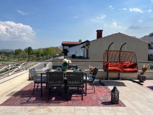 eine Terrasse mit einem Tisch und Stühlen auf dem Dach in der Unterkunft Waterfront Terrace House Bosphorus Istanbul in Istanbul