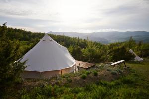 una tienda blanca sentada en la cima de una colina en Agricola Ombra - Tents in nature en Laiatico