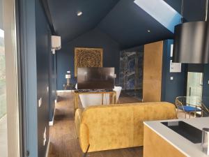 INFINITY HOUSES في بونتي دا بارسا: غرفة معيشة بجدران زرقاء وأريكة صفراء