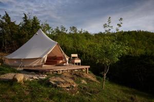 Tienda blanca con terraza de madera en un campo en Agricola Ombra - Tents in nature, en Lajatico