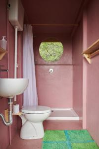 a pink bathroom with a toilet and a sink at Agricola Ombra - Tents in nature in Laiatico