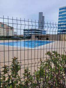 a swimming pool behind a fence with a building at Residence 5 etoiles Orya Park avec piscine in Istanbul