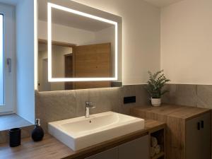 uma casa de banho com um lavatório e um espelho em Alpenglow Apartments em Collalbo