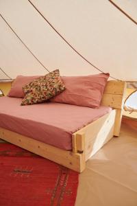 uma cama numa tenda com duas almofadas em Agricola Ombra - Tents in nature em Lajatico