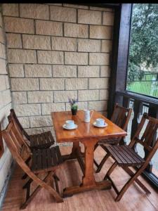 uma mesa de madeira e 2 cadeiras num pátio em Vivienda de uso Turístico LARA 