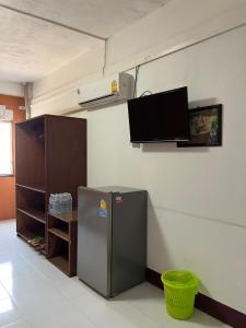 a room with a refrigerator and a tv on the wall at GG Sweet Home in Mae Sot