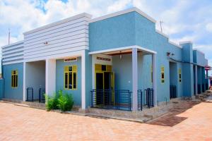 a blue and white building on a brick street at IREBERO DREAM HOME in Kayonza