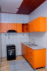 a kitchen with orange cabinets and a sink at IREBERO DREAM HOME in Kayonza +12 photos
