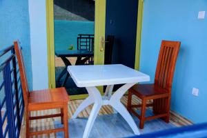 a white table and two chairs and a mirror at IREBERO DREAM HOME in Kayonza