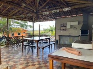 eine Küche und einen Essbereich mit Tischen und Stühlen in der Unterkunft Sítio Lourenço Marques Serra do Cipó MG in Serra do Cipo