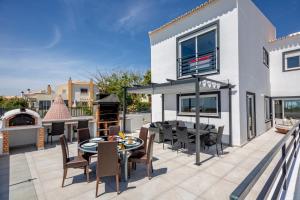 un patio con tavolo, sedie e griglia di Villa Avalon by Algarve Vacation a Pêra