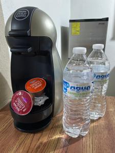 een koffiezetapparaat en 2 flessen water op een tafel bij Casa Málaga in Zamora de Hidalgo