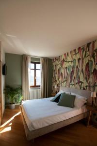 1 dormitorio con 1 cama grande y una pintura en la pared en Coltivare AgriRelais, en La Morra