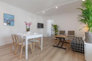 a white dining room with a white table and chairs at Flamingo Center Clemenceau in Béziers