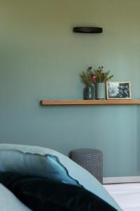 a room with a bed and a shelf on the wall at Coltivare AgriRelais in La Morra