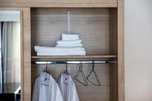 a closet with white clothes and towels on a shelf at Coresi rezidence & suites in Braşov