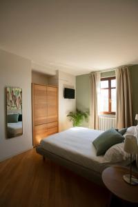 Un dormitorio con una cama grande y una ventana en Coltivare AgriRelais, en La Morra