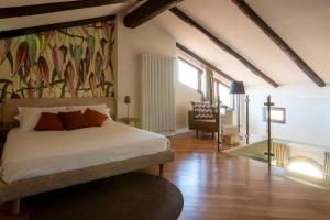 a bedroom with a bed and a painting on the wall at Coltivare AgriRelais in La Morra