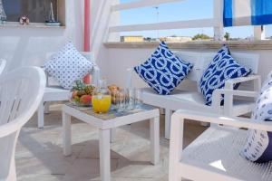 Zimmer mit weißen Stühlen und blauen und weißen Kissen in der Unterkunft Residence il Porto di Mare in Porto Cesareo