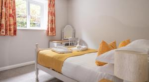 a bedroom with a bed with a mirror and a window at Bassenthwaite in Sawrey