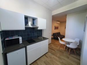a kitchen with white cabinets and a table and chairs at B75 Apartments Bilbao in Bilbao
