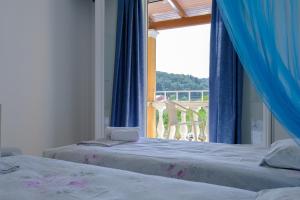 1 Schlafzimmer mit 2 Betten und einem Fenster mit Aussicht in der Unterkunft Bardis Hotel in Arillas