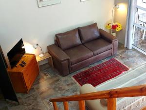 a living room with a brown couch and a television at Suites on 74 in Worcester