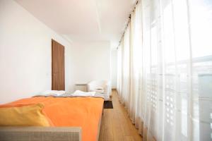 a bedroom with an orange bed and a window at Cozy Apartment with Mountain View & Parking in Sofia