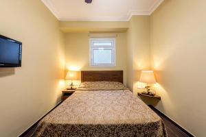 een slaapkamer met een bed met 2 lampen en een televisie bij Domina Coral Bay building 46 by Holiday Home 24 in Sharm El Sheikh